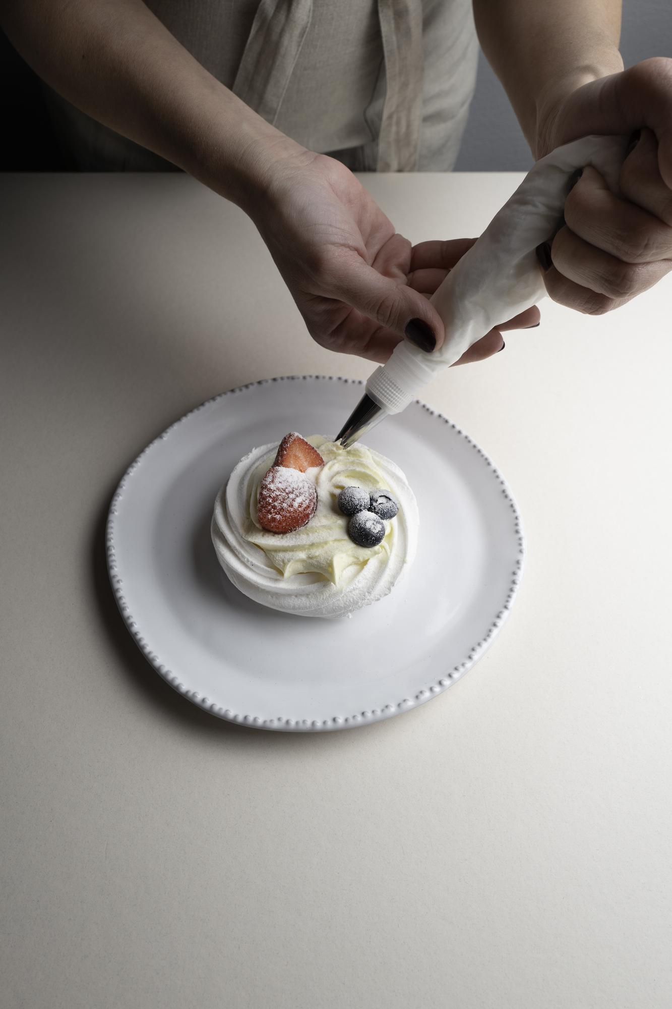 Student plating a dessert with precision