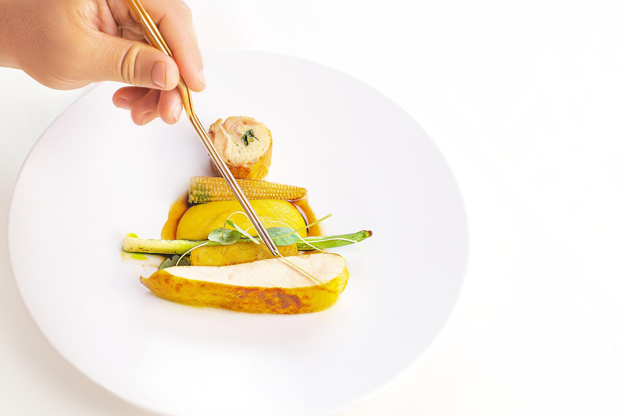 Instructor arranging plated dish in pastel studio